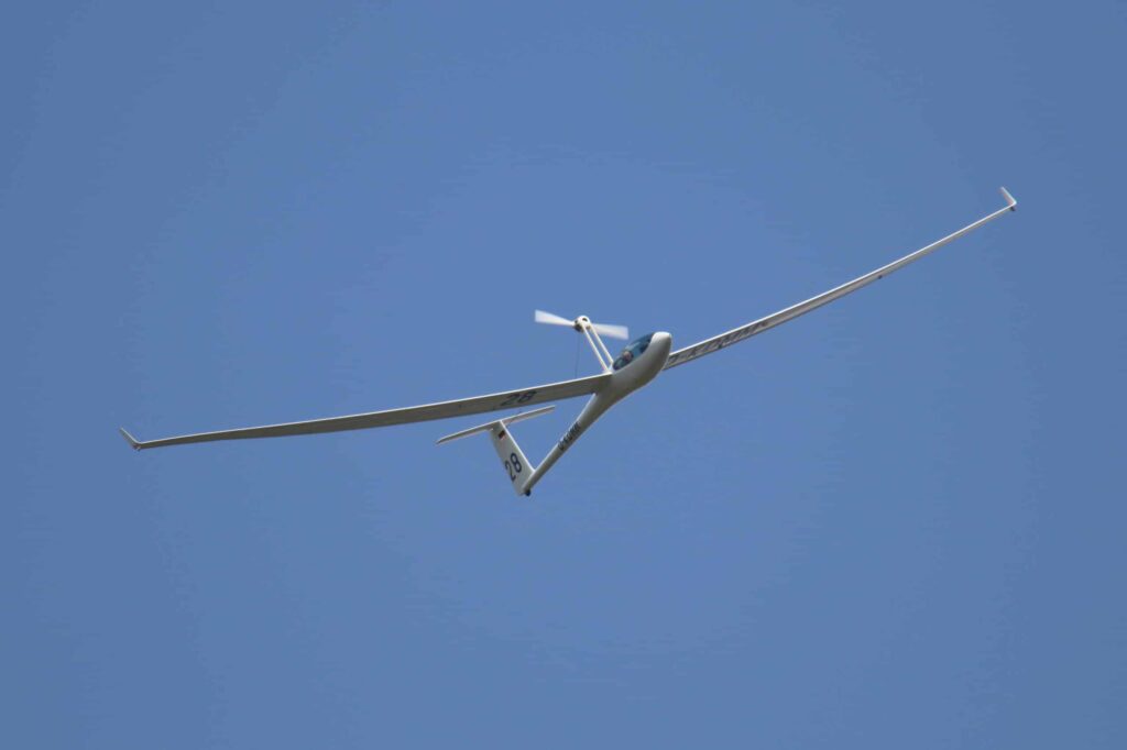 Segelflugzeug mit ausegfahrenem Elektromotor in der Luft